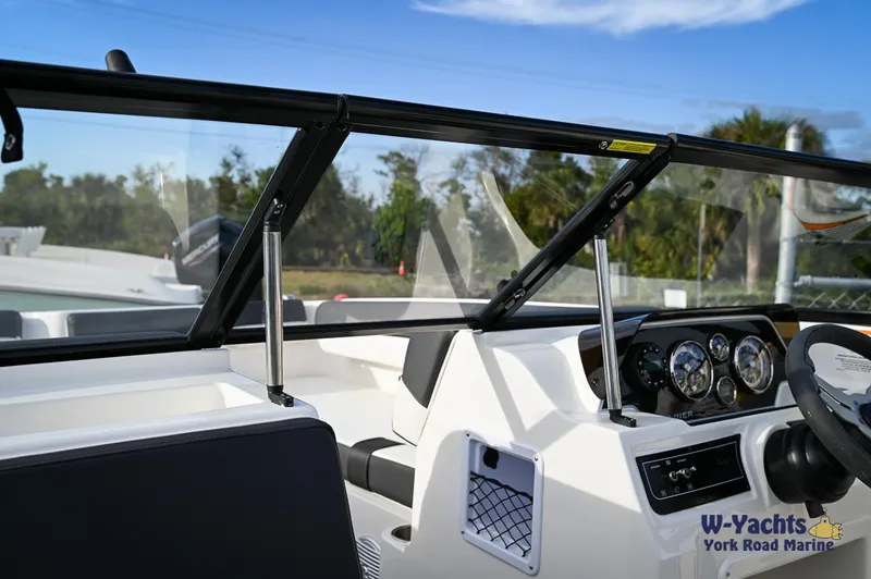 Slide: The Image of 2024 Bayliner DX2000 boat dashboard and cockpit area. - 15