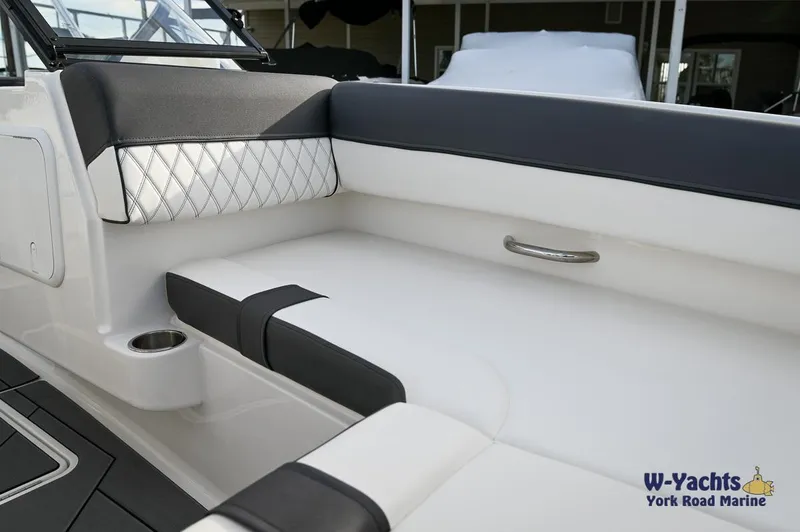 Slide: The Image of 2024 Bayliner DX2000 boat interior with white and black seating, cup holder, and grab handle. - 5