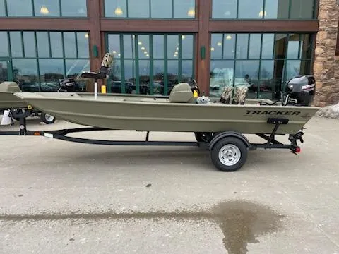 The Image of 2024 Tracker Grizzly 1754 SC fishing boat on trailer, parked outside a building. - 0