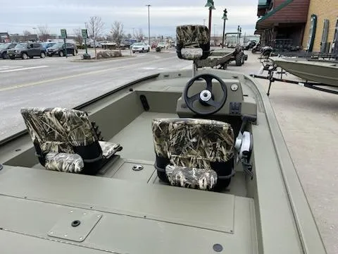 Slide: The Image of 2024 Tracker Grizzly 1754 SC boat with camo seats, steering wheel, and console. - 2