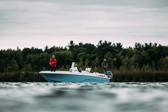 Slide: The Image of 2023 Wellcraft 222 Fisherman boat on a lake with two people fishing. - 24