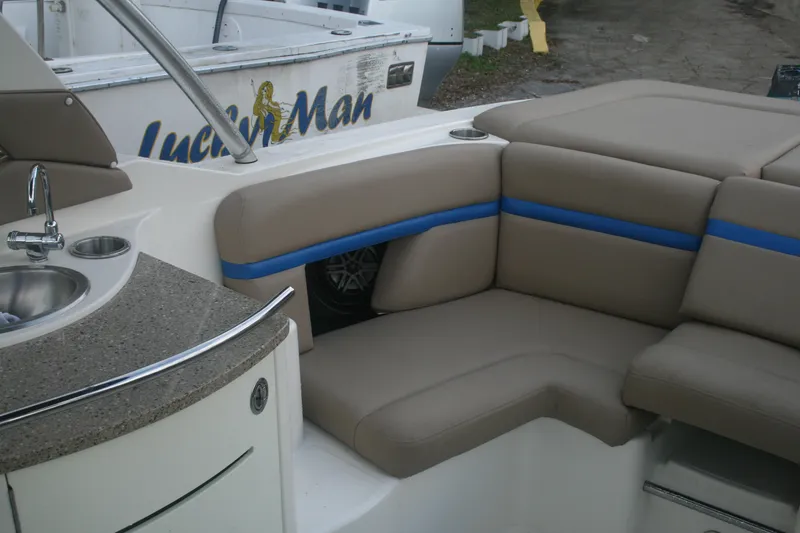 Slide: The Image of 2014 Sea Ray 270 SLX boat interior with beige seating and kitchenette. - 13