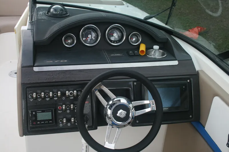 Slide: The Image of 2014 Sea Ray 270 SLX boat dashboard with steering wheel and control panel. - 14
