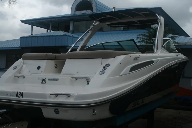 Slide: The Image of 2014 Sea Ray 270 SLX boat docked near a blue building. - 3