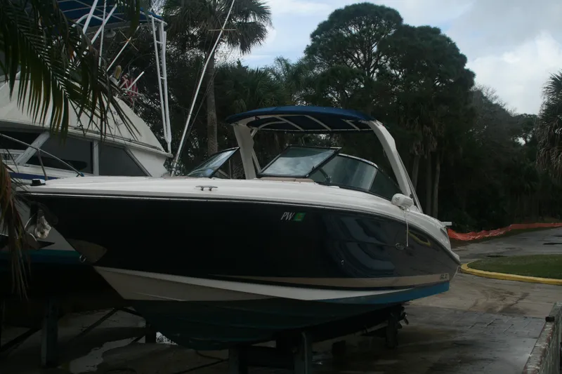 Slide: The Image of 2014 Sea Ray 270 SLX boat docked near trees and other boats. - 31
