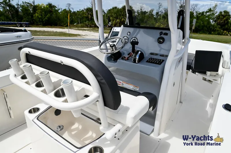 Slide: The Image of 2023 Bayliner T24 boat interior with steering console and rod holders. - 12