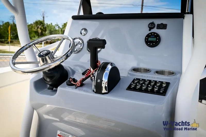 Slide: The Image of 2023 Bayliner T24 boat helm with steering wheel, throttle, and control panel. - 15
