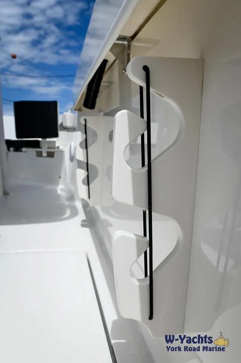 Slide: The Image of 2023 Bayliner T24 boat interior with rod holders, blue sky background. - 23