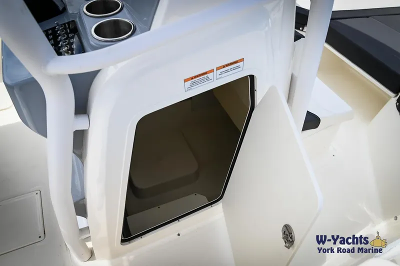 Slide: The Image of 2023 Bayliner T24 boat interior with open storage compartment and control panel. - 31