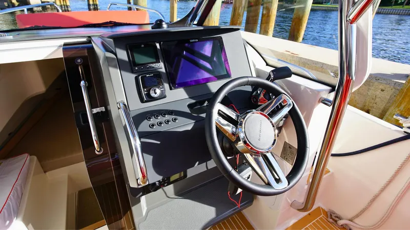 Slide: The Image of 2024 Nimbus Tender 8 #281 boat cockpit with steering wheel and control panel. - 13