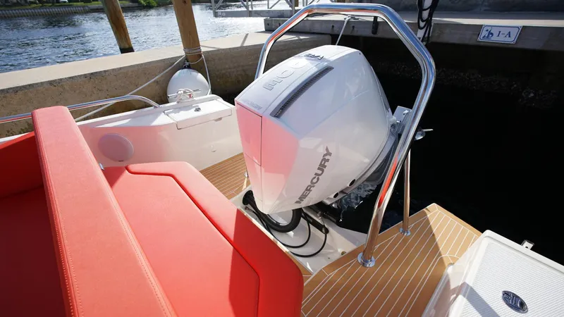 Slide: The Image of 2024 Nimbus Tender 8 #281 with Mercury outboard engine and red seating, docked by water. - 17