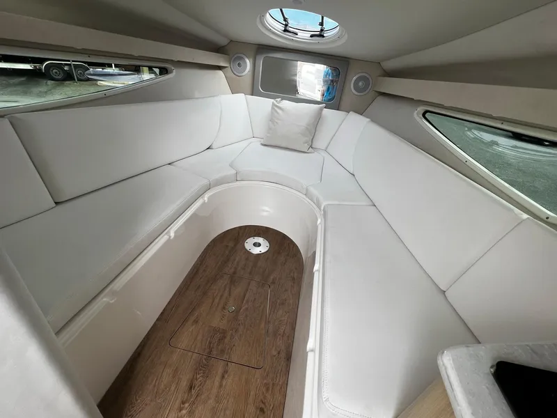 Slide: The Image of 2024 Regal 28 Express cabin interior with white seating and wood flooring. - 15