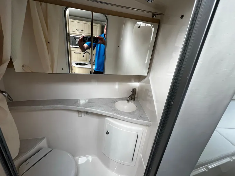 Slide: The Image of 2024 Regal 28 Express bathroom with sink, mirror, and toilet. - 17