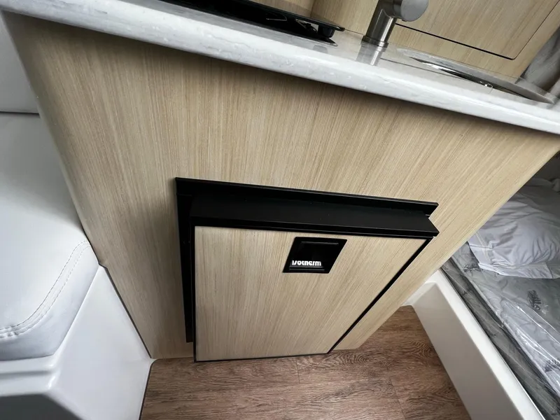Slide: The Image of 2024 Regal 28 Express boat interior with compact refrigerator and sink. - 21