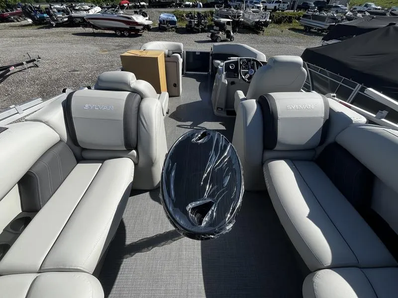 Slide: The Image of 2024 Sylvan Mirage 8524 LZ pontoon boat interior with seating and table. - 2