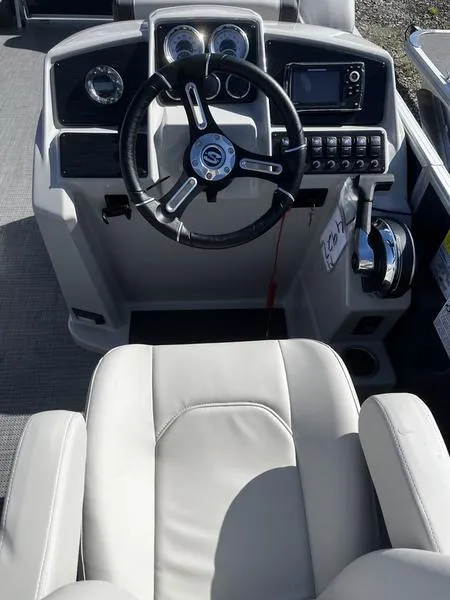 Slide: The Image of 2024 Sylvan Mirage 8524 LZ boat cockpit with steering wheel and control panel. - 6