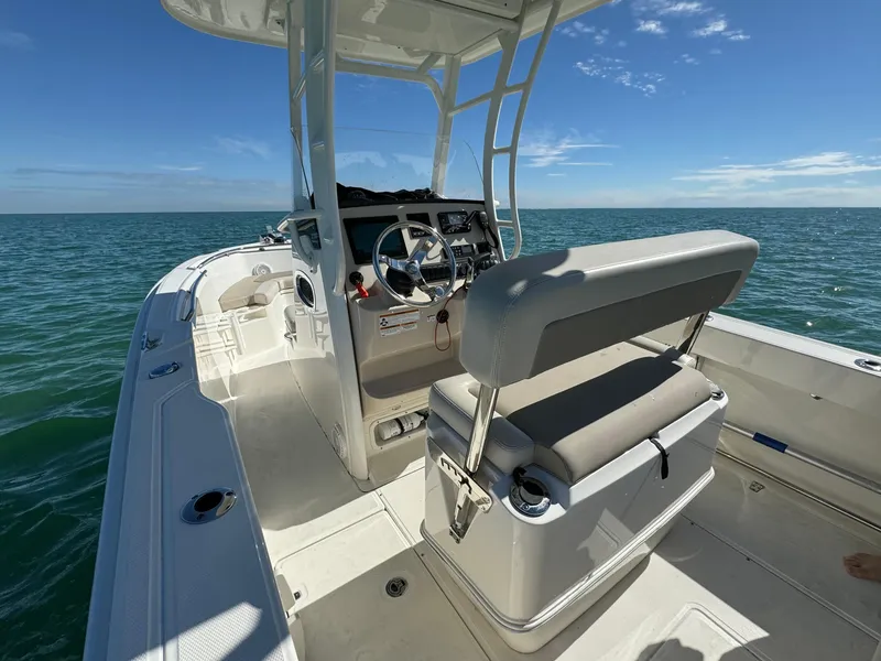 Slide: The Image of 2022 Boston Whaler 230 Outrage boat on open water, featuring helm and seating area. - 14