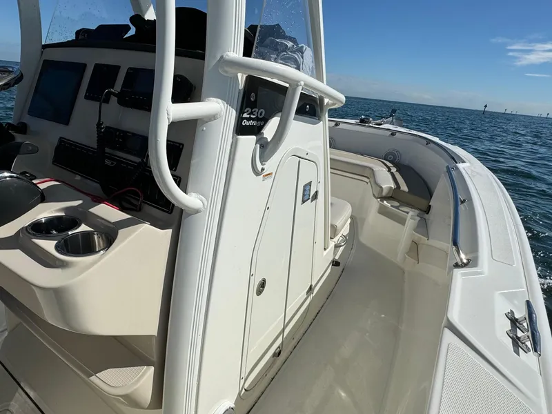 Slide: The Image of 2022 Boston Whaler 230 Outrage boat interior with console and seating, on open water. - 17