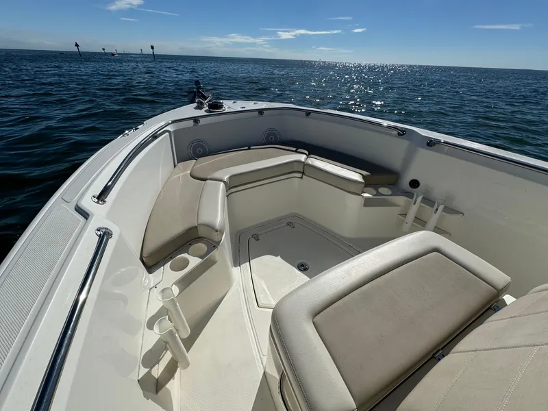 Slide: The Image of 2022 Boston Whaler 230 Outrage boat interior with cushioned seating on open water. - 25
