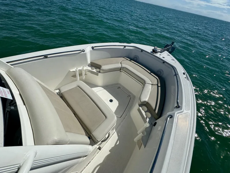 Slide: The Image of 2022 Boston Whaler 230 Outrage boat interior with cushioned seating on open water. - 26