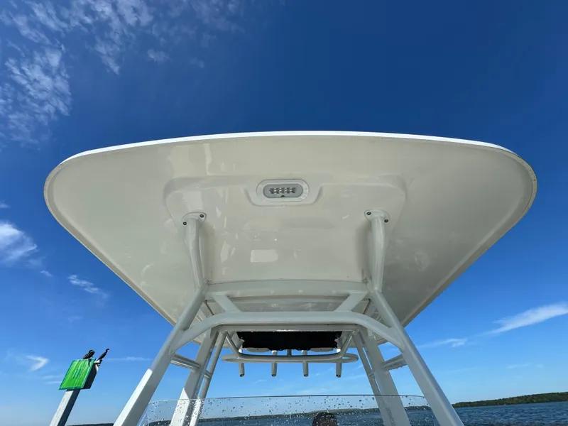 Slide: The Image of Boston Whaler 230 Outrage 2022 boat T-top against clear blue sky. - 32