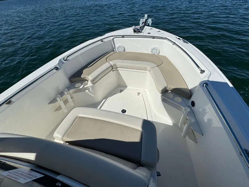 Slide: The Image of 2022 Boston Whaler 230 Outrage boat interior with cushioned seating on water. - 33