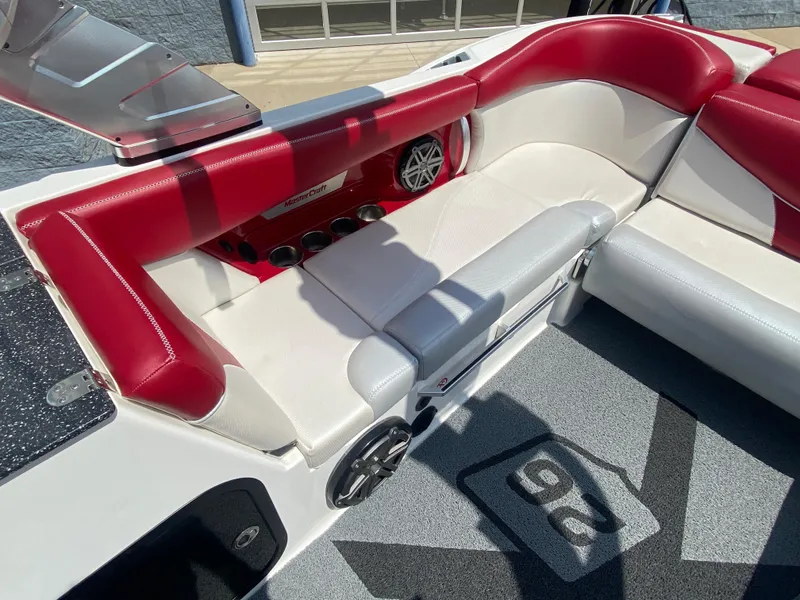 Slide: The Image of 2017 MasterCraft X26 boat interior with red and white seating and speaker system. - 11