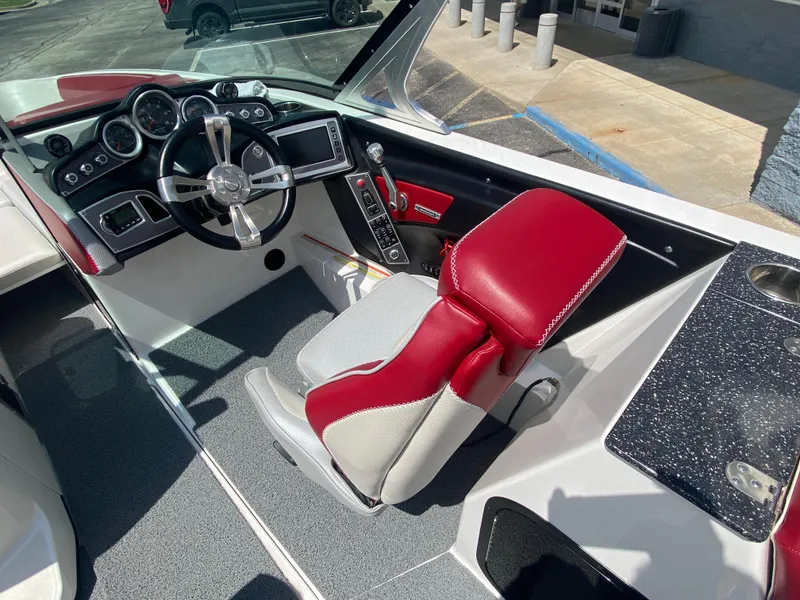 Slide: The Image of 2017 MasterCraft X26 boat cockpit with red and white seating, modern controls, and steering wheel. - 16