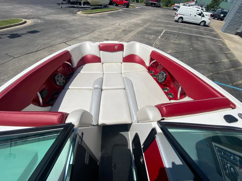 Slide: The Image of 2017 MasterCraft X26 boat interior with red and white seating in a parking lot. - 26