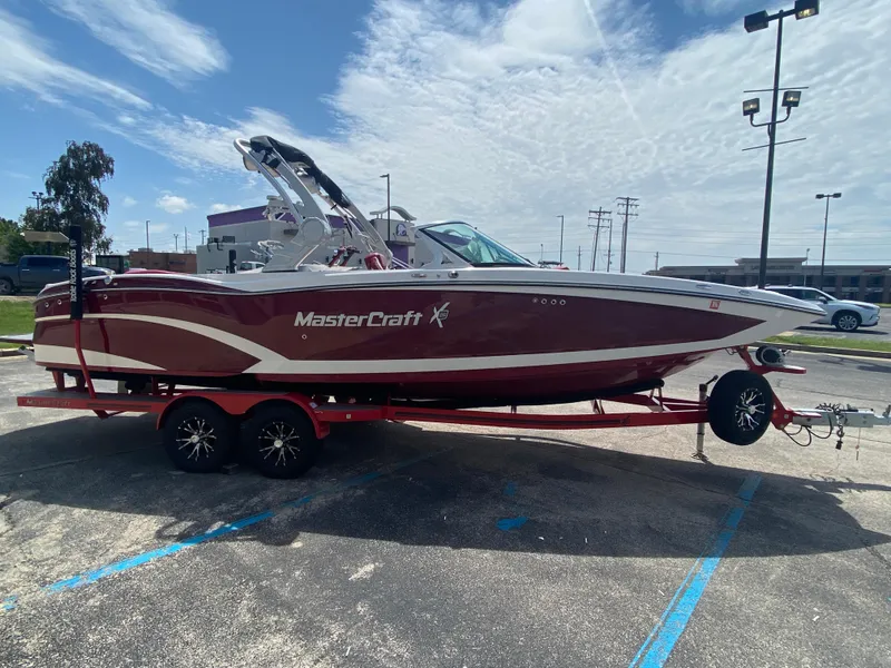 Slide: The Image of 2017 MasterCraft X26 boat on trailer in parking lot under cloudy sky. - 3