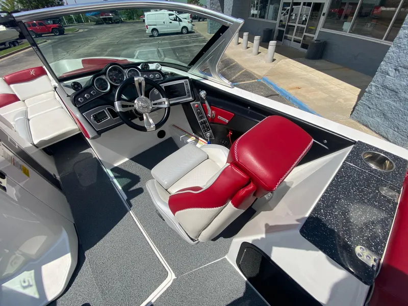 Slide: The Image of 2017 MasterCraft X26 boat interior with red and white seating, steering wheel, and dashboard controls. - 30