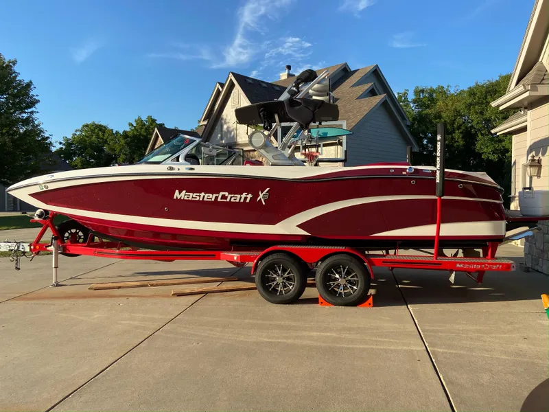 Slide: The Image of 2017 MasterCraft X26 boat on trailer, parked in driveway, sunny day. - 37