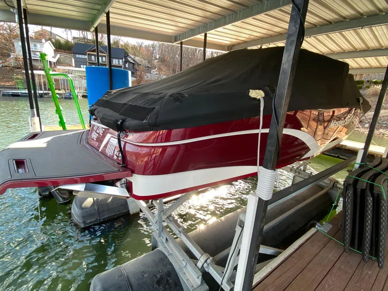Slide: The Image of 2017 MasterCraft X26 boat covered and docked on a lift in a lakeside setting. - 39