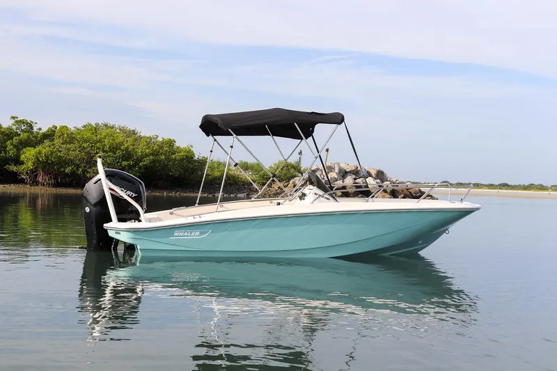 Slide: The Image of 2024 Boston Whaler 160 Super Sport boat on calm water with canopy. - 13