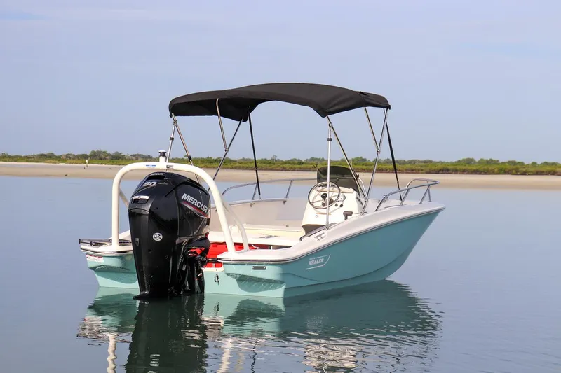 Slide: The Image of 2024 Boston Whaler 160 Super Sport boat on calm water with canopy and outboard motor. - 14