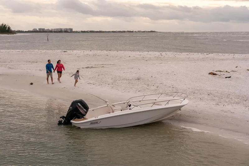 Slide: The Image of 2024 Boston Whaler 160 Super Sport on sandy beach with family nearby. - 22