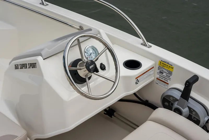 Slide: The Image of 2024 Boston Whaler 160 Super Sport steering console with controls and gauges. - 26