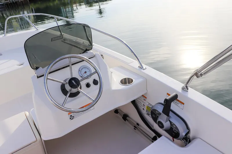 Slide: The Image of 2024 Boston Whaler 160 Super Sport boat dashboard with steering wheel and controls. - 32