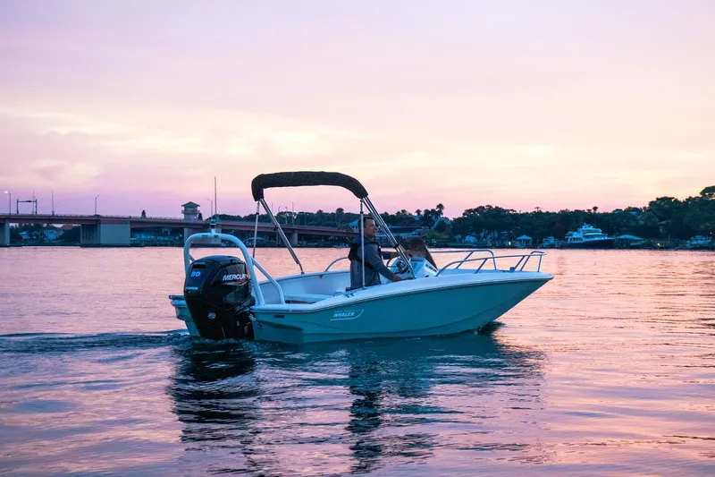 Slide: The Image of 2024 Boston Whaler 160 Super Sport boat cruising at sunset on calm waters. - 36