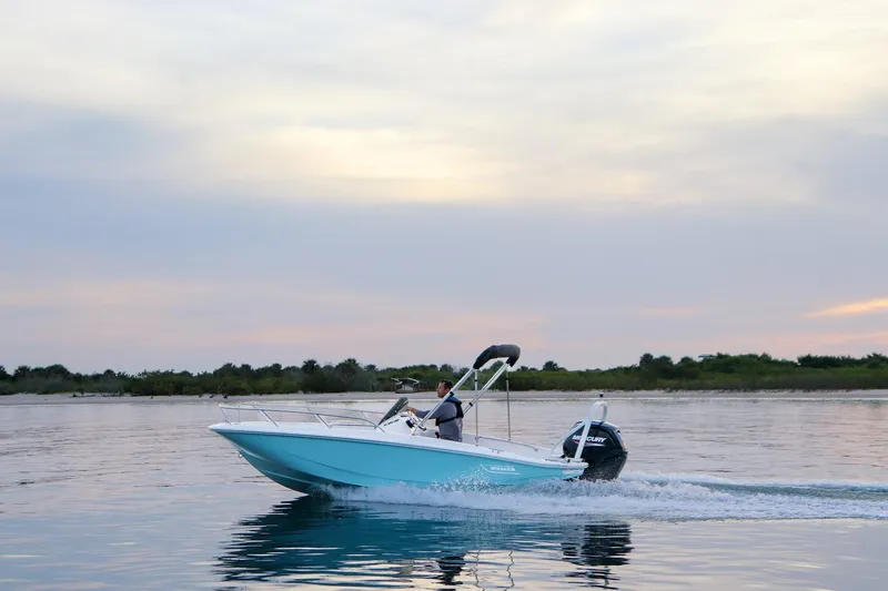 Slide: The Image of 2024 Boston Whaler 160 Super Sport cruising on calm waters at sunset. - 6