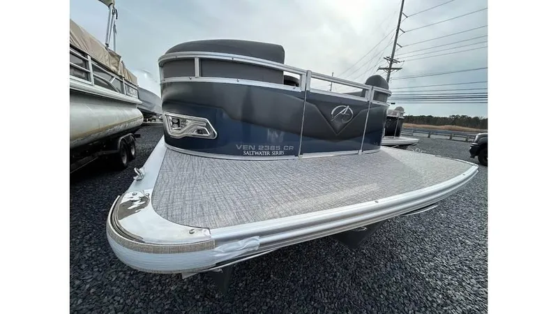 Slide: The Image of 2024 Avalon 2385 V 85 CR pontoon boat, front view on gravel lot. - 3