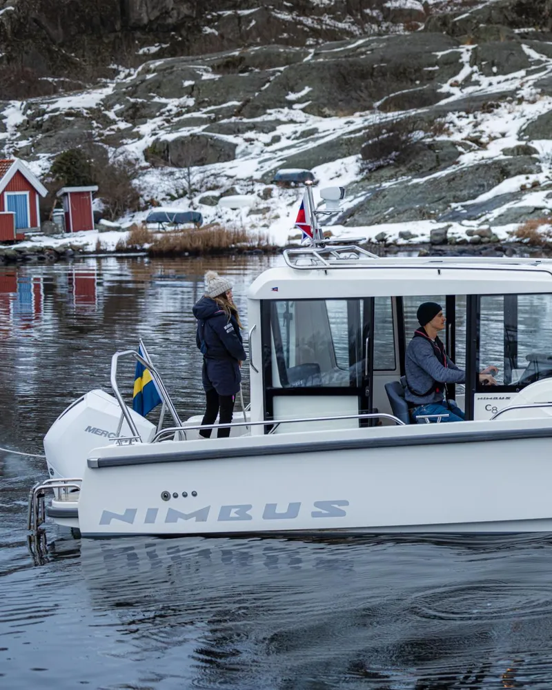 Slide: The Image of 2024 Nimbus C8 boat cruising in a snowy coastal area. - 19