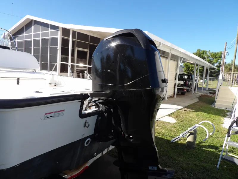 Slide: The Image of 2008 Boston Whaler 190 Nantucket boat with outboard motor in a residential yard. - 17