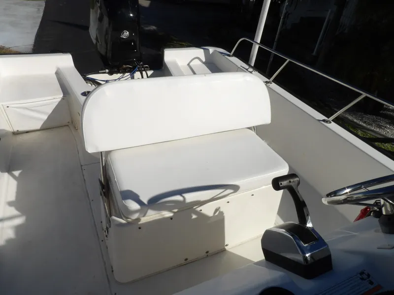 Slide: The Image of 2008 Boston Whaler 190 Nantucket boat interior with white seating and steering console. - 8