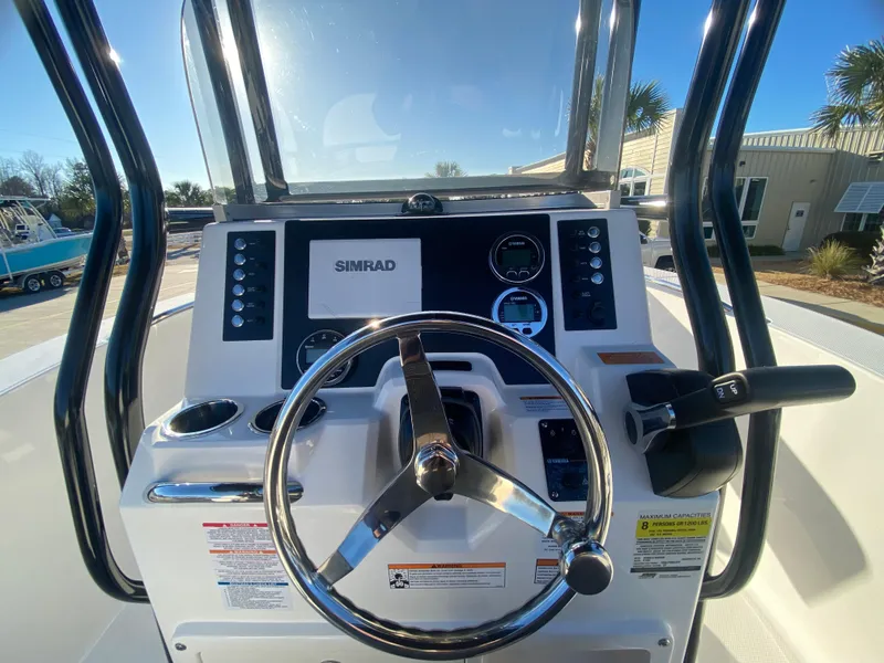 Slide: The Image of 2024 Robalo R200 Center Console boat helm with Simrad display and steering wheel. - 10