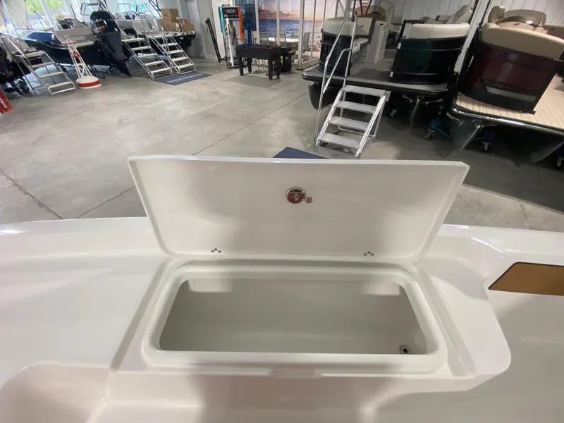 Slide: The Image of Open storage compartment of a 2024 Savannah 210X boat in a showroom. - 16