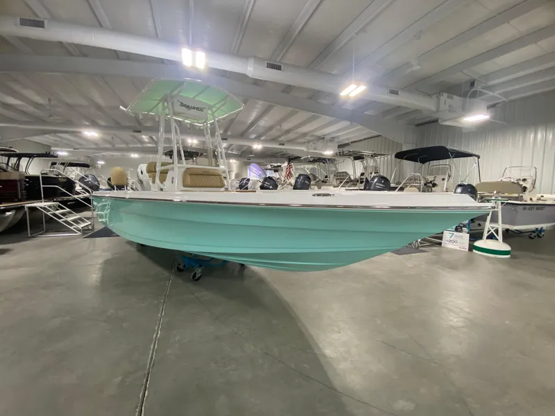 Slide: The Image of 2024 Savannah 210X boat displayed in an indoor showroom. - 2