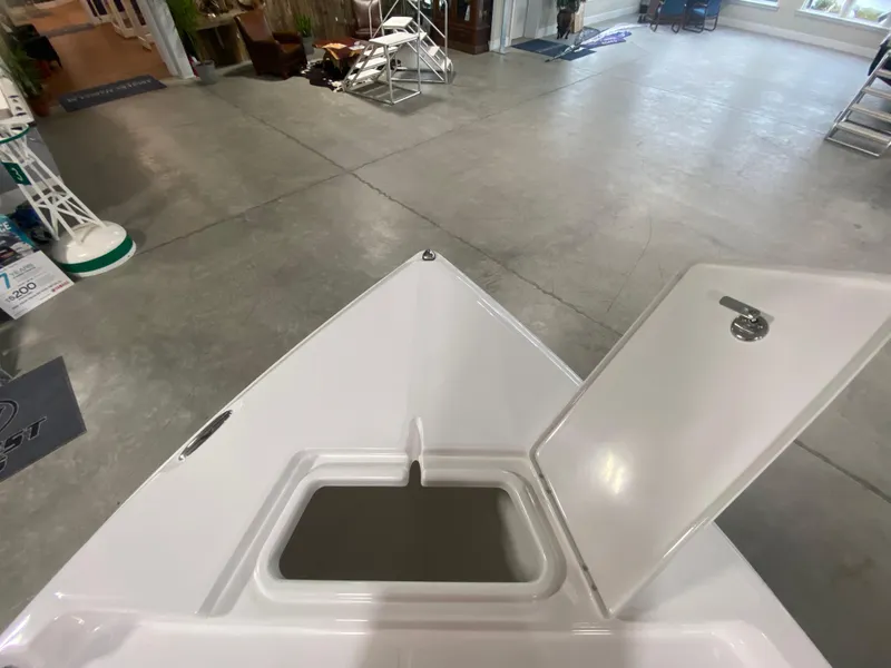 Slide: The Image of 2024 Savannah 210X boat with open storage compartment in showroom. - 20