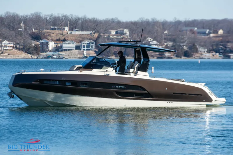 The Image of 2024 Invictus GT320 luxury motorboat cruising on a lake near residential area. - 0