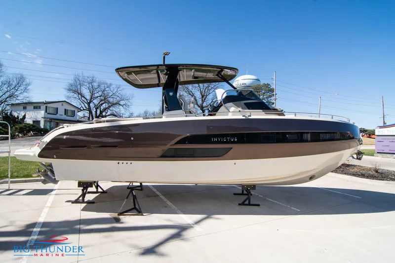 Slide: The Image of 2024 Invictus GT320 luxury motorboat displayed on stands at a marina. - 11